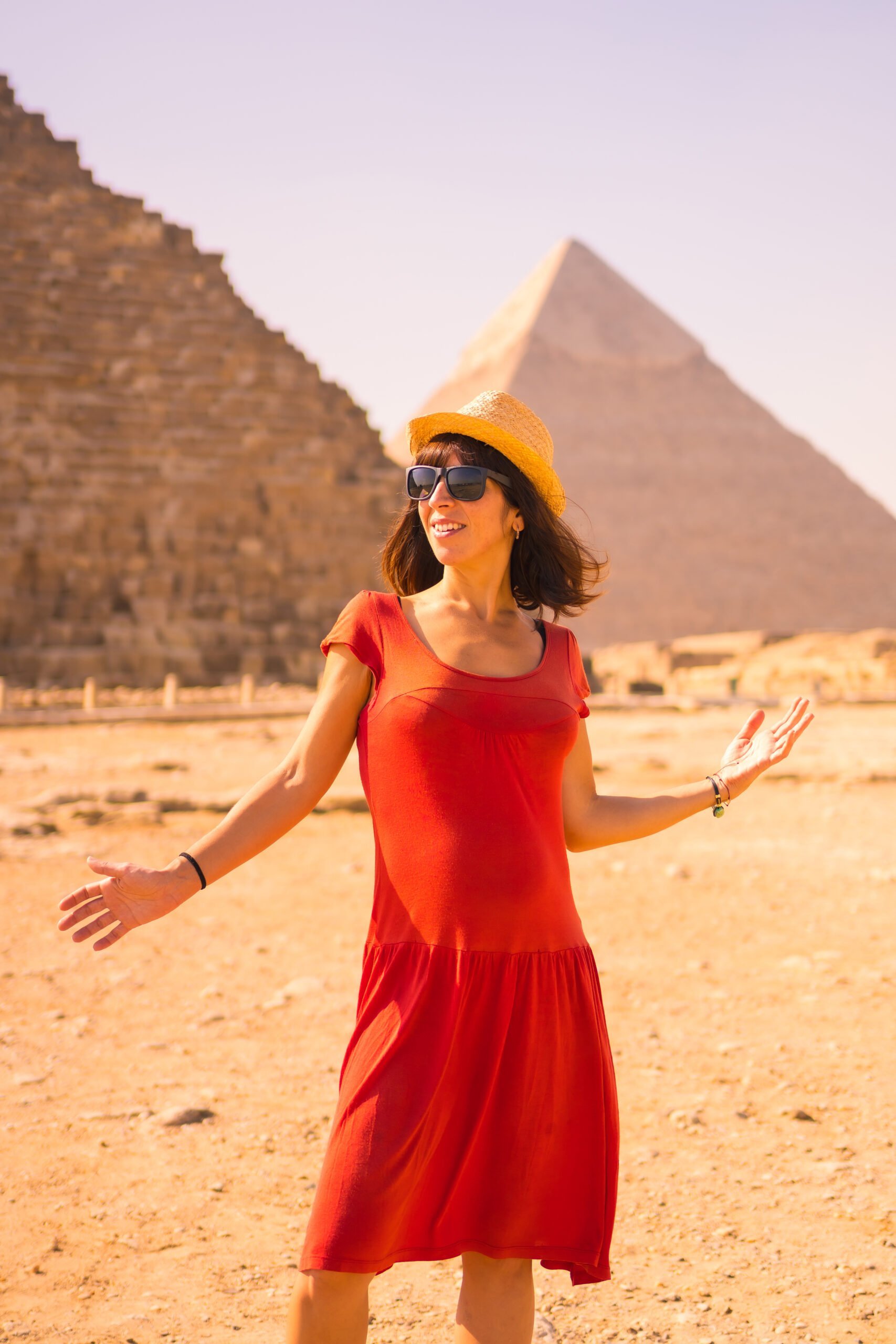 Portrait of a young girl in red dress at the pyramid of Cheops the largest pyramid. The pyramids of Giza the oldest funerary monument in the world. In the city of Cairo, Egypt