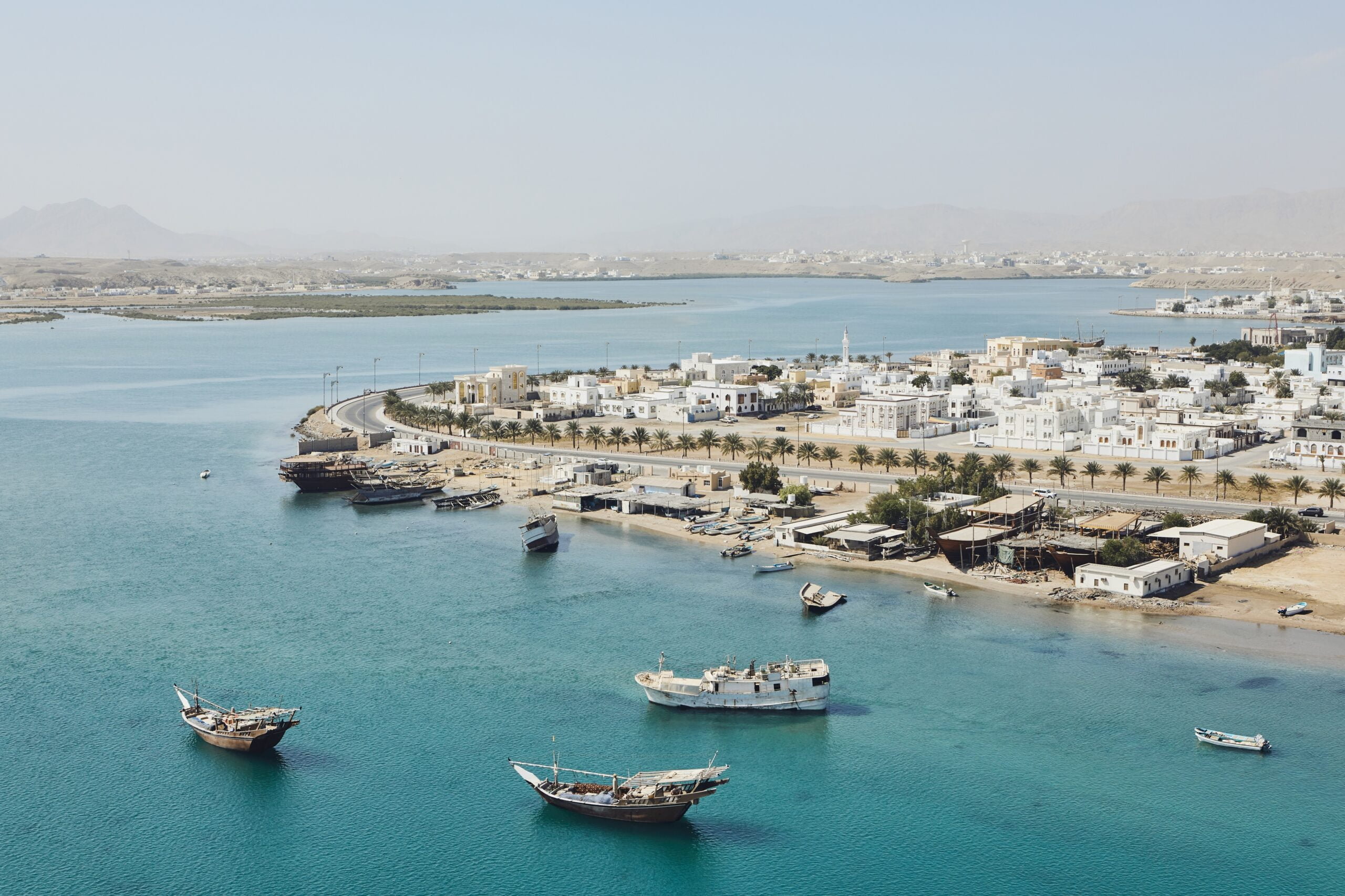 Bay with traditional wooden Dhow ships. Coastline of old city Sur in Sultanate of Oman.